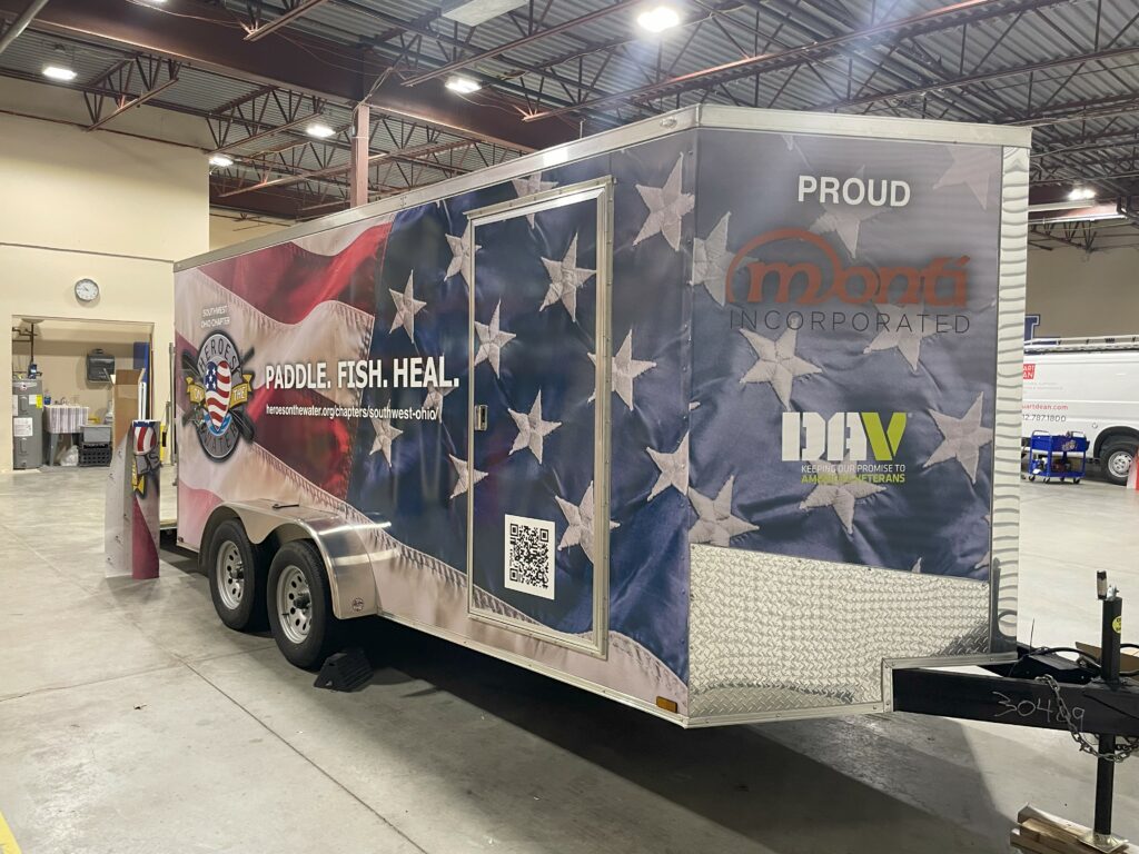 mage of a trailer wrapped with a custom vinyl design. This design has the American Flag, with the logo for Heroes on the Water on top.