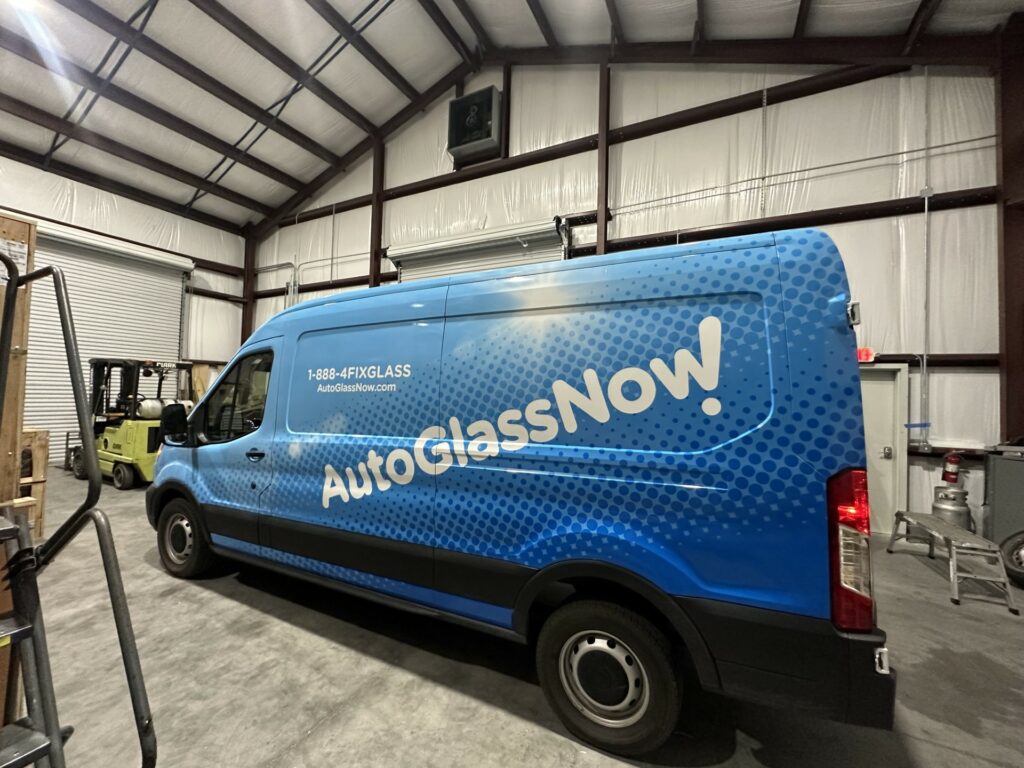 New full wrap vehicle for AutoGlassNow! Blue vehicle wrap pictured in a garage after an install.